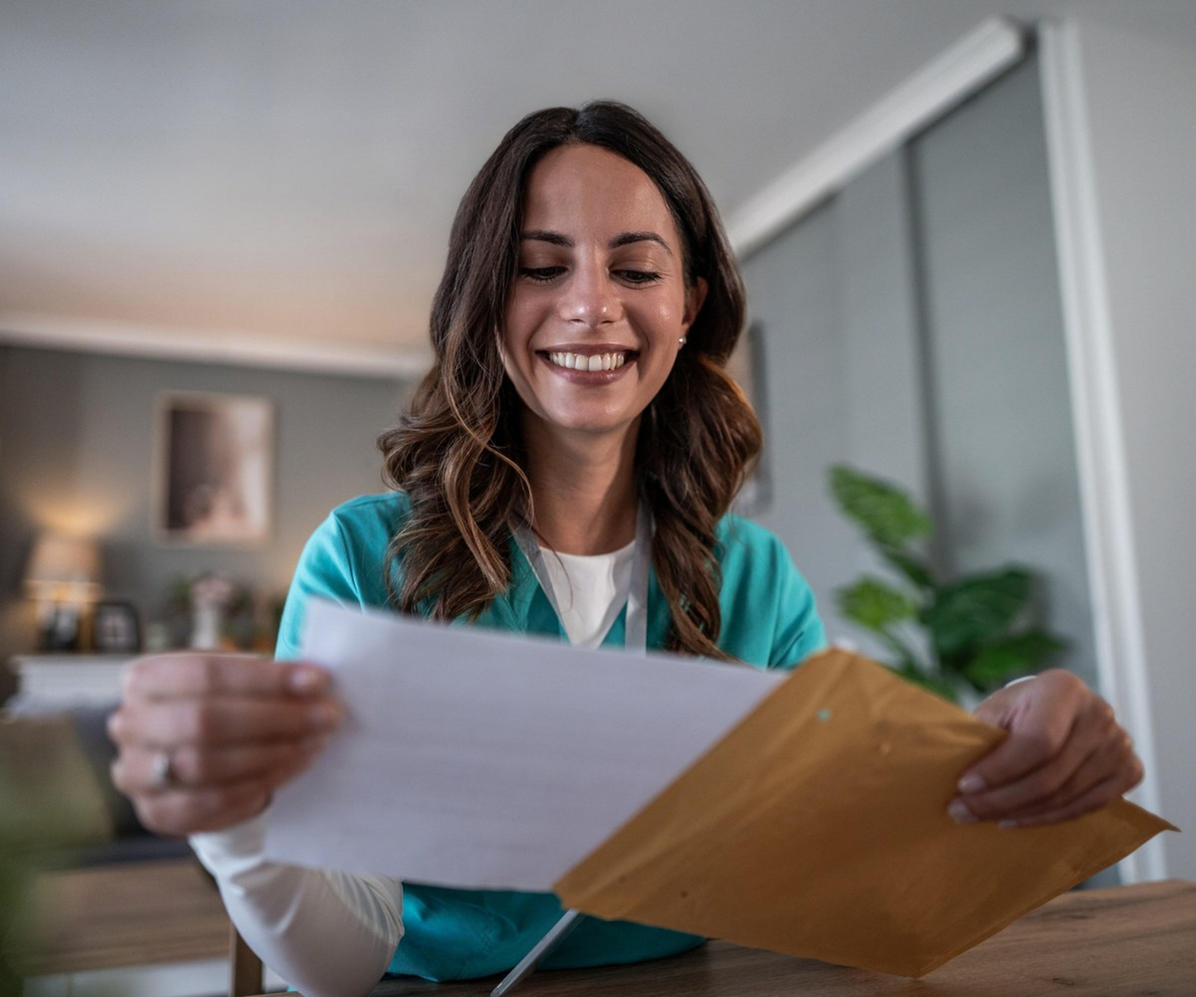 Woman opening an envelope and reviewing mailed documents