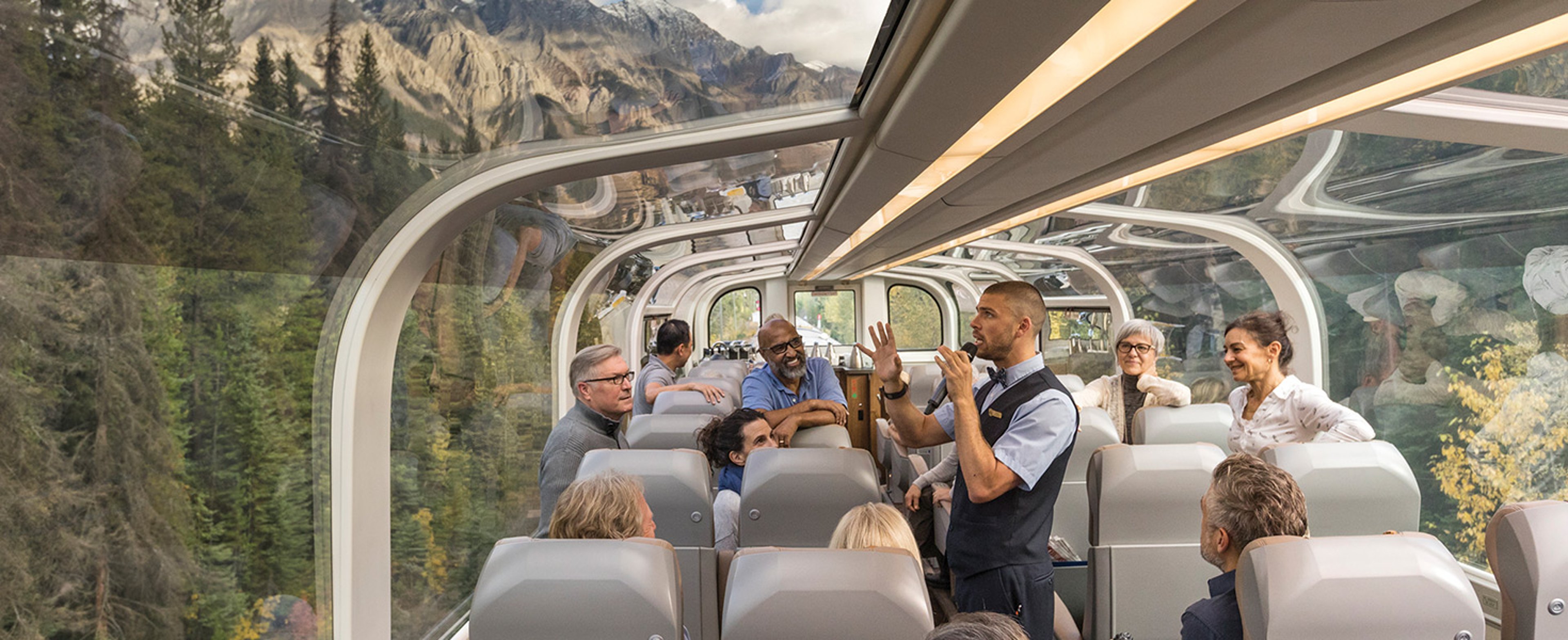 Travelers aboard Rocky Mountaineer train enjoying the glass domed car in Goldleaf service