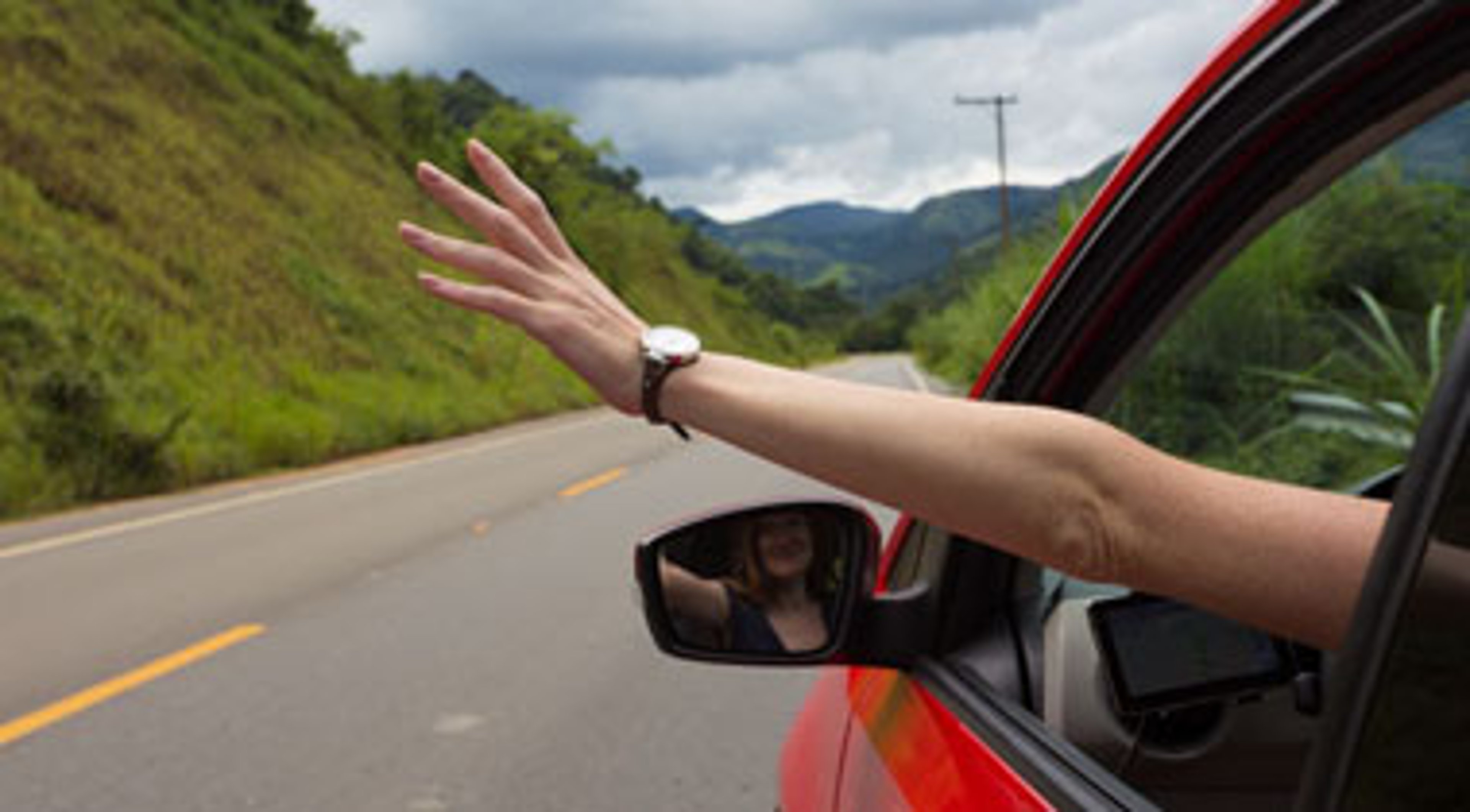 Lady holding hand out of car window