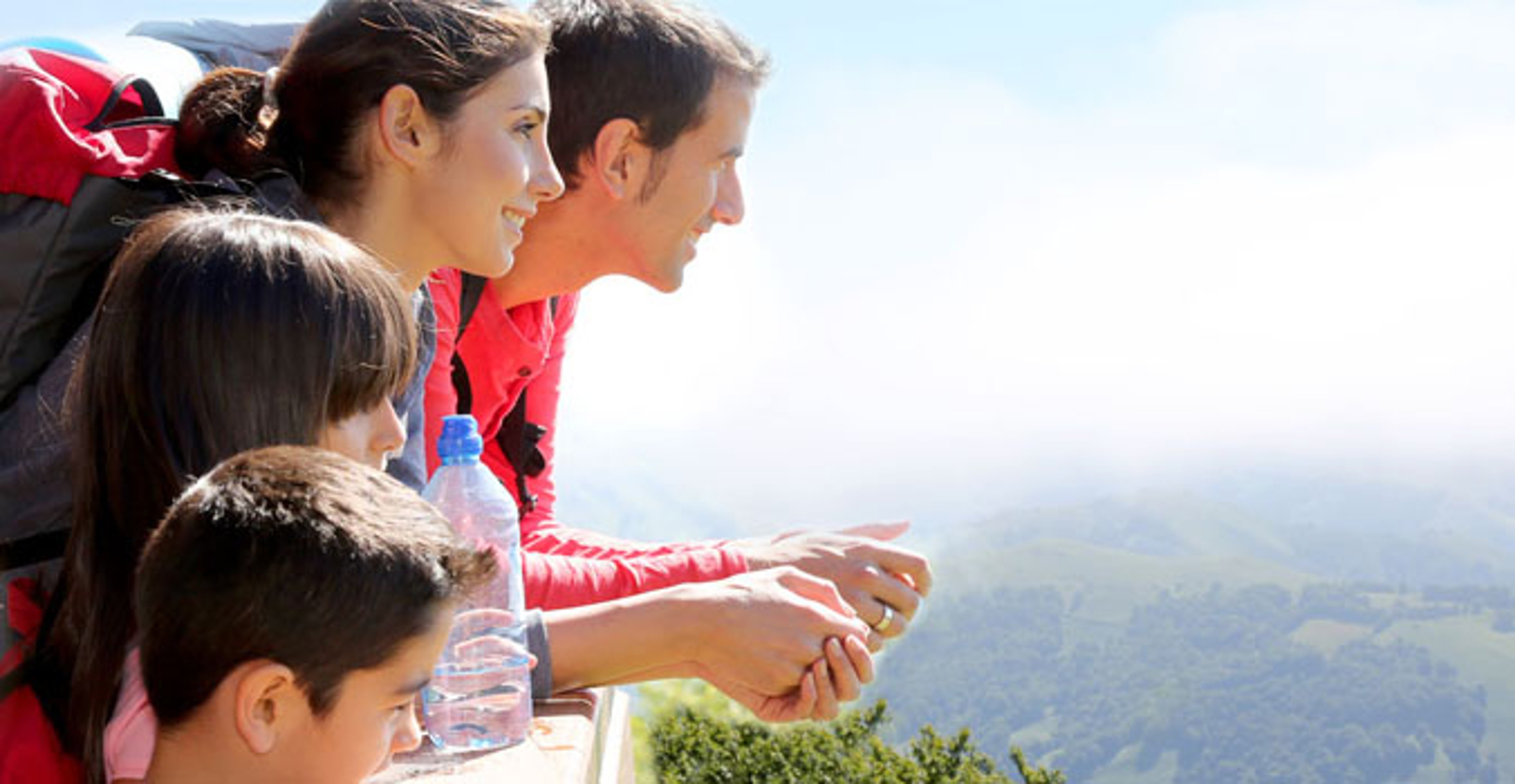 Family backpackers at the mountain looking at the valley view