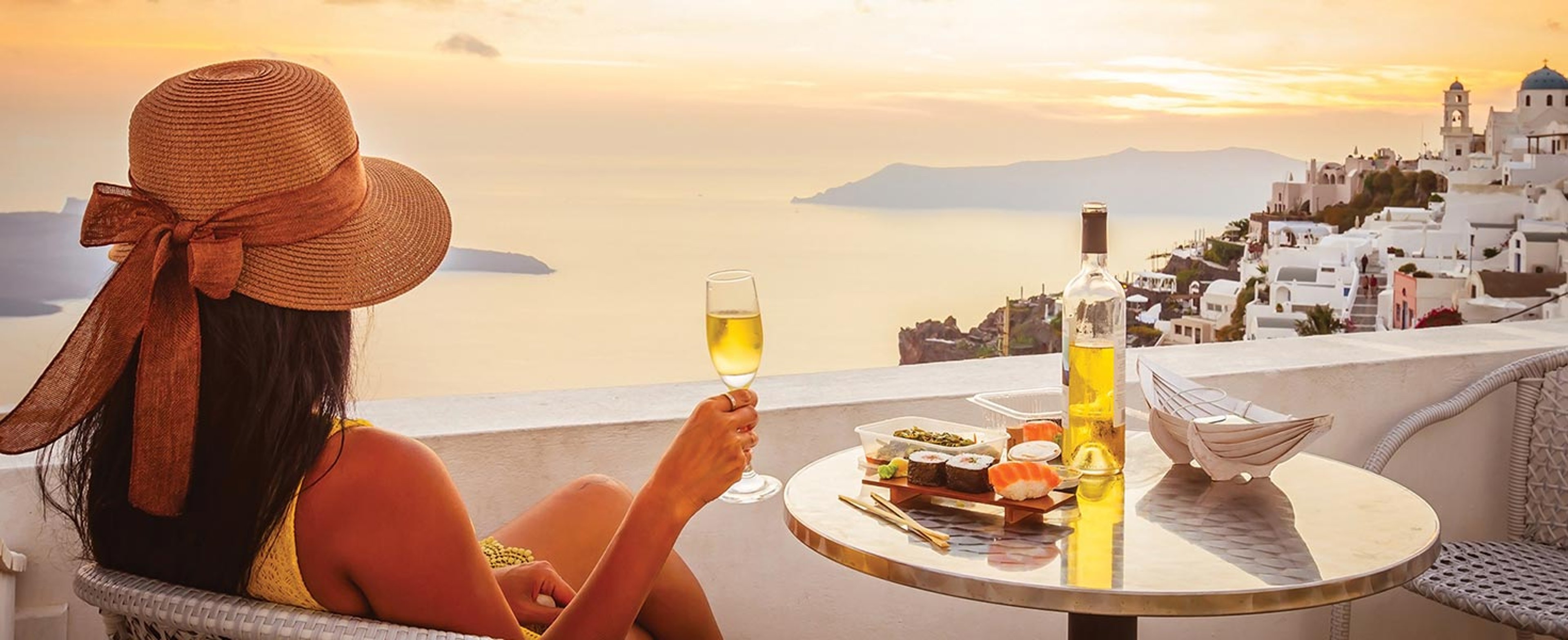 Woman drinking wine while overlooking the ocean