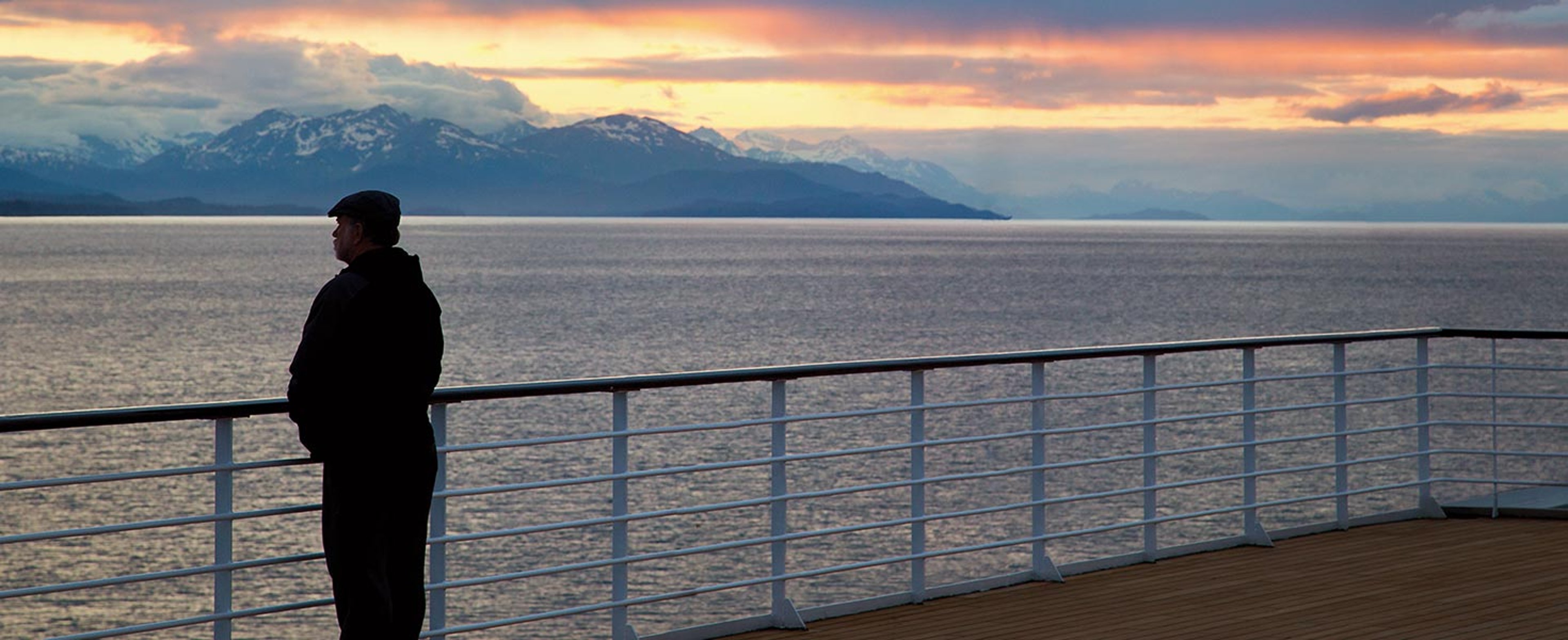 Oceania cruiser standing on deck looking out over ocean