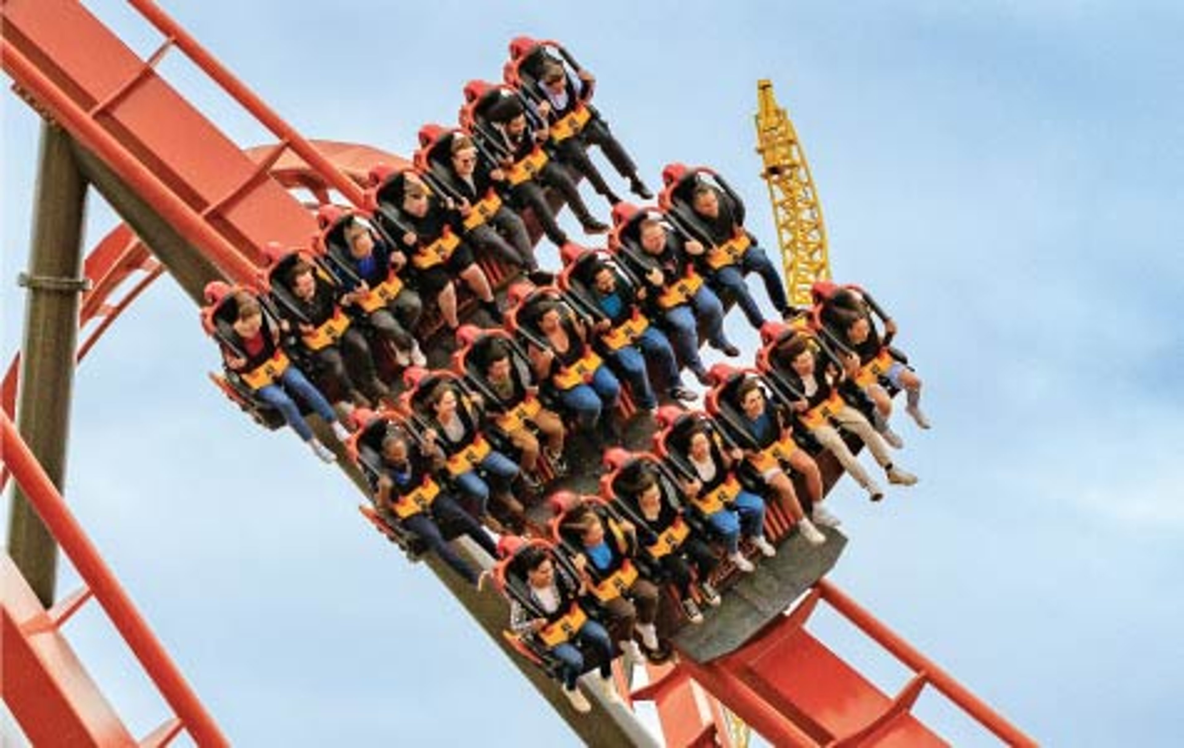 A wide-angle shot of the Iron Menace dive roller coaster at Dorney Park against a bright, cloudy sky.