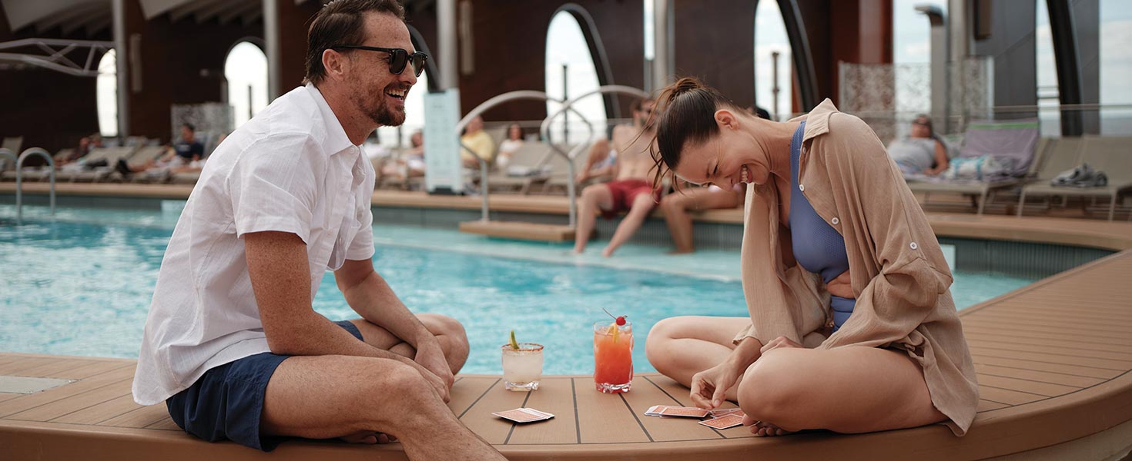 Couple enjoying drinks poolside 