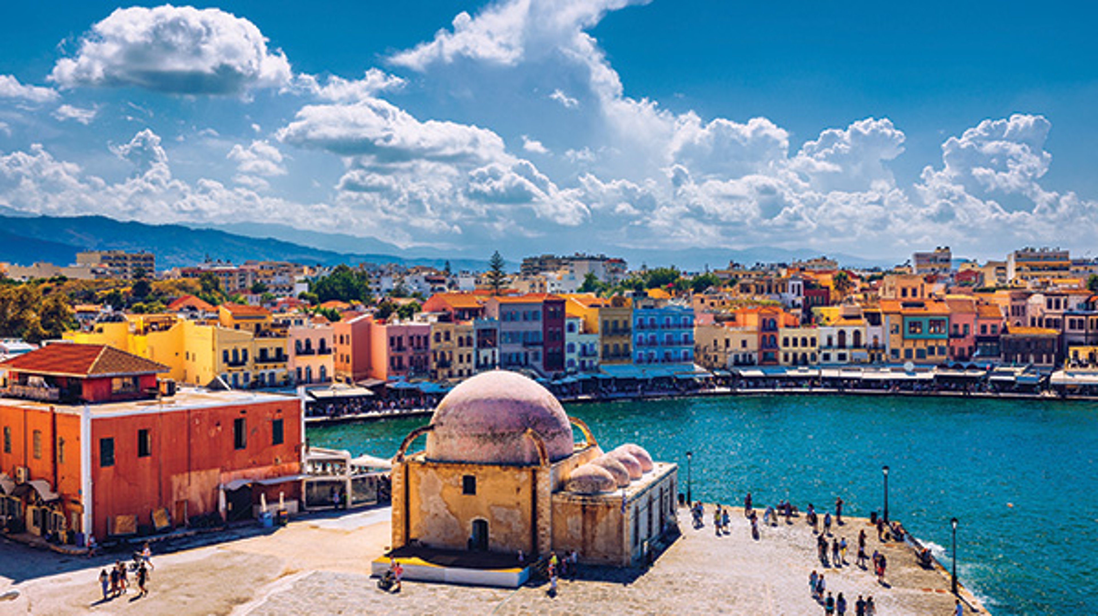 Old Venetian Port of Chania with colorful waterfront buildings and a historic domed structure.