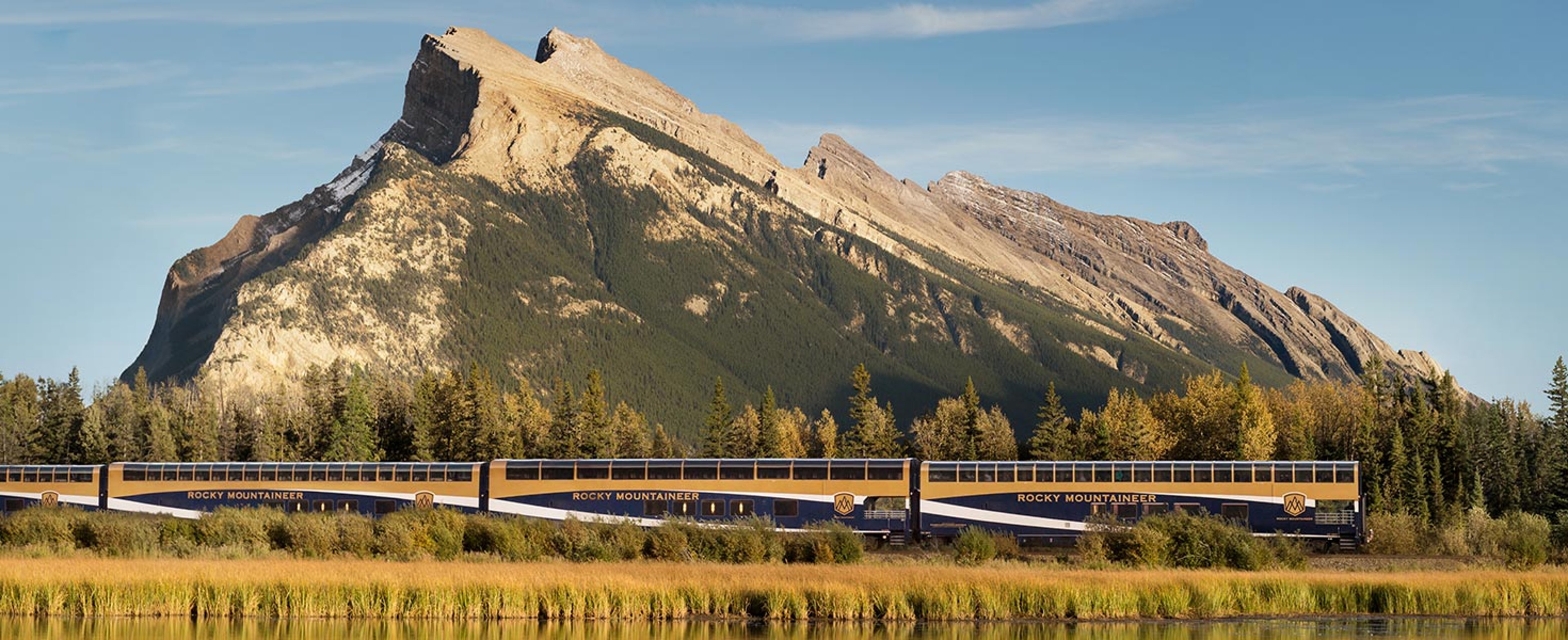 Rocky Mountaineer train traveling in front of a mountain