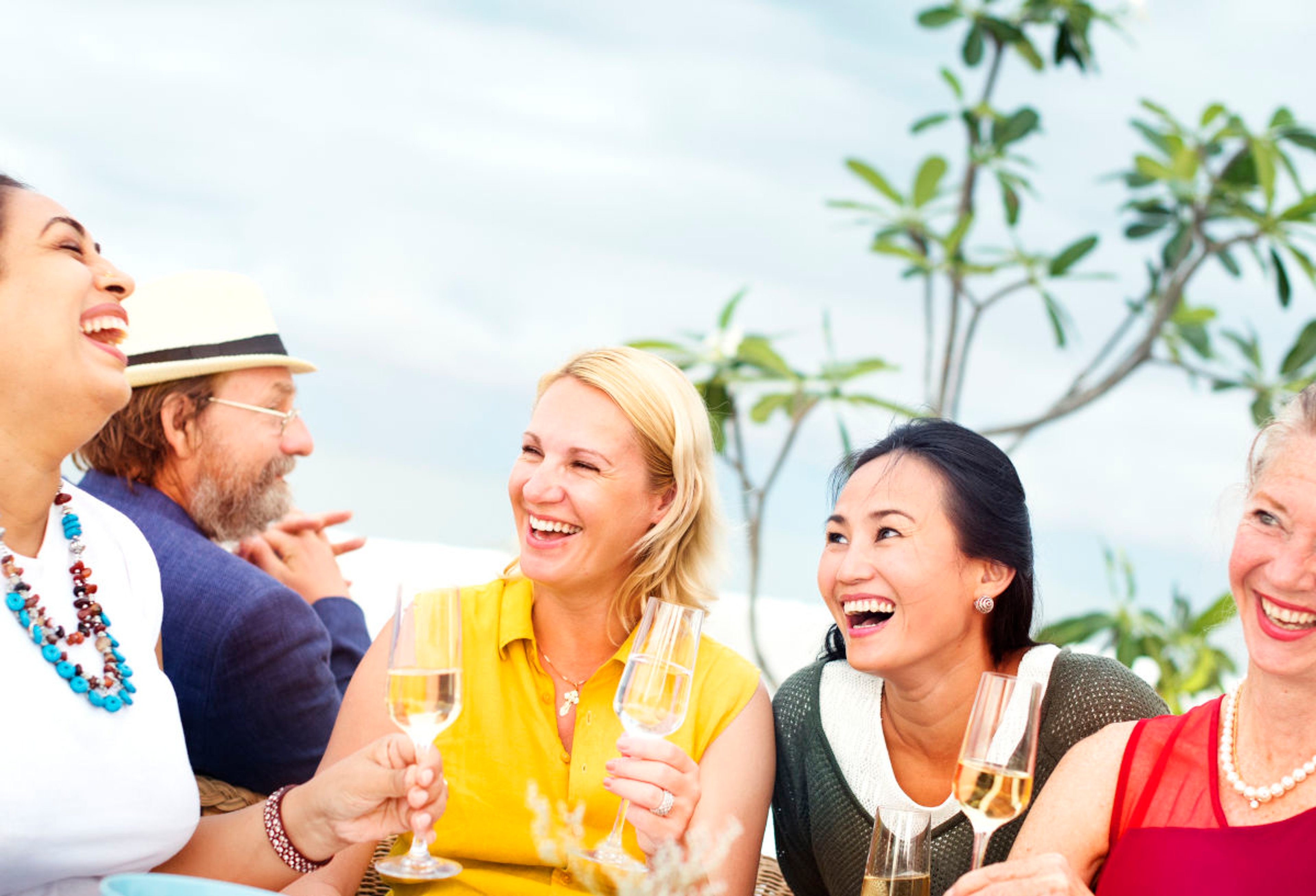Traveling women smiling and enjoying cocktails on resort vacation 