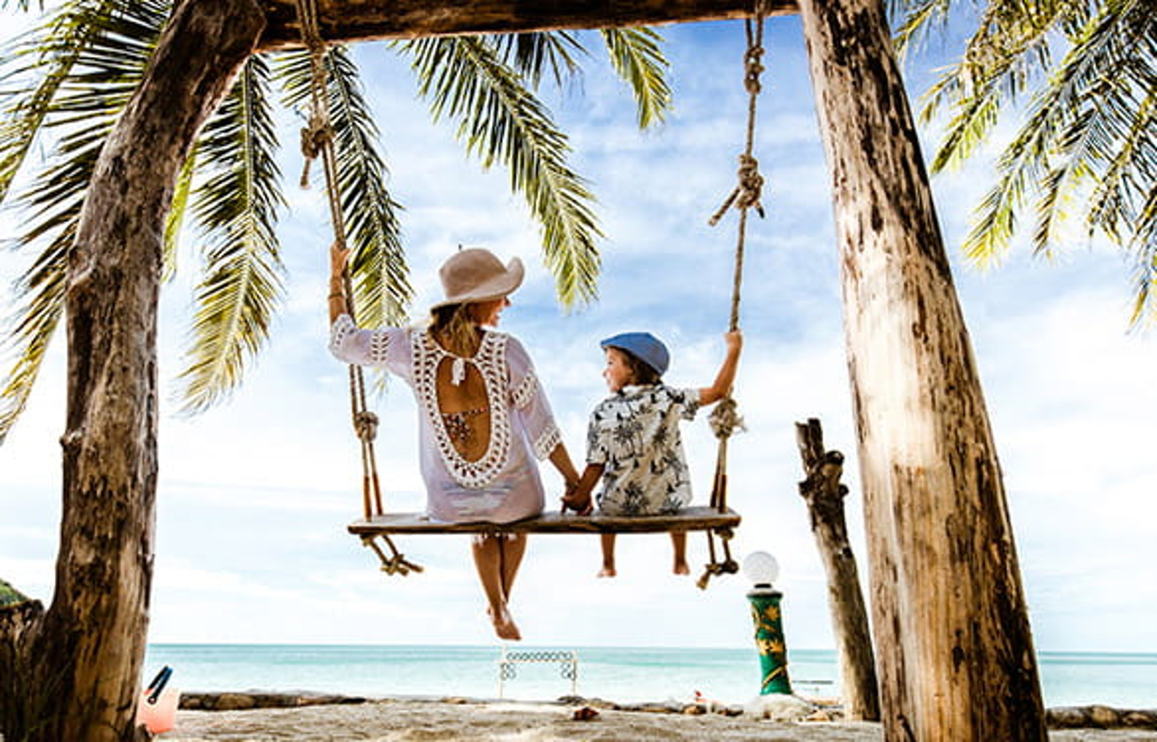 Mom and son on beach swing