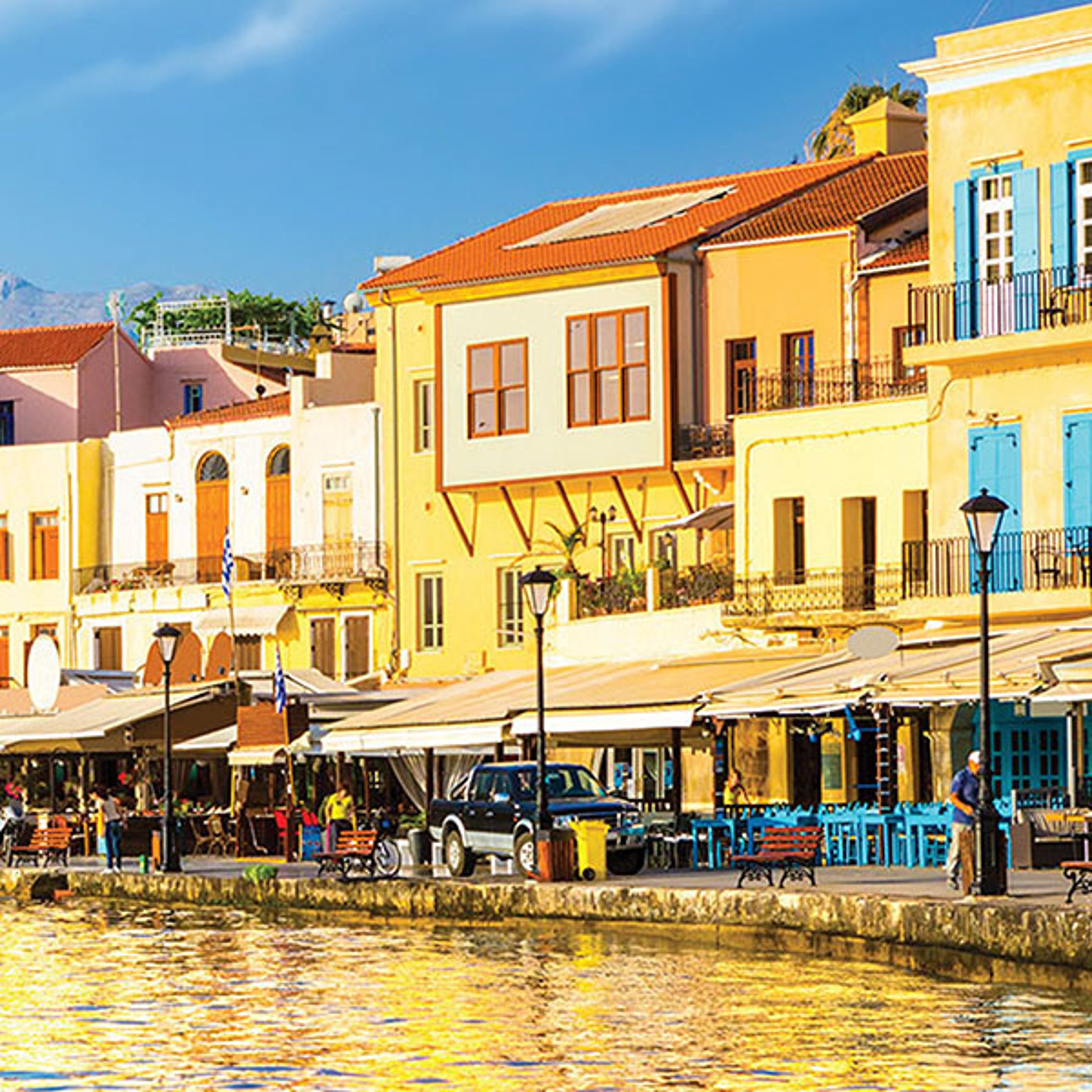 Old Venetian Port of Chania at sunrise with buildings reflecting on the water