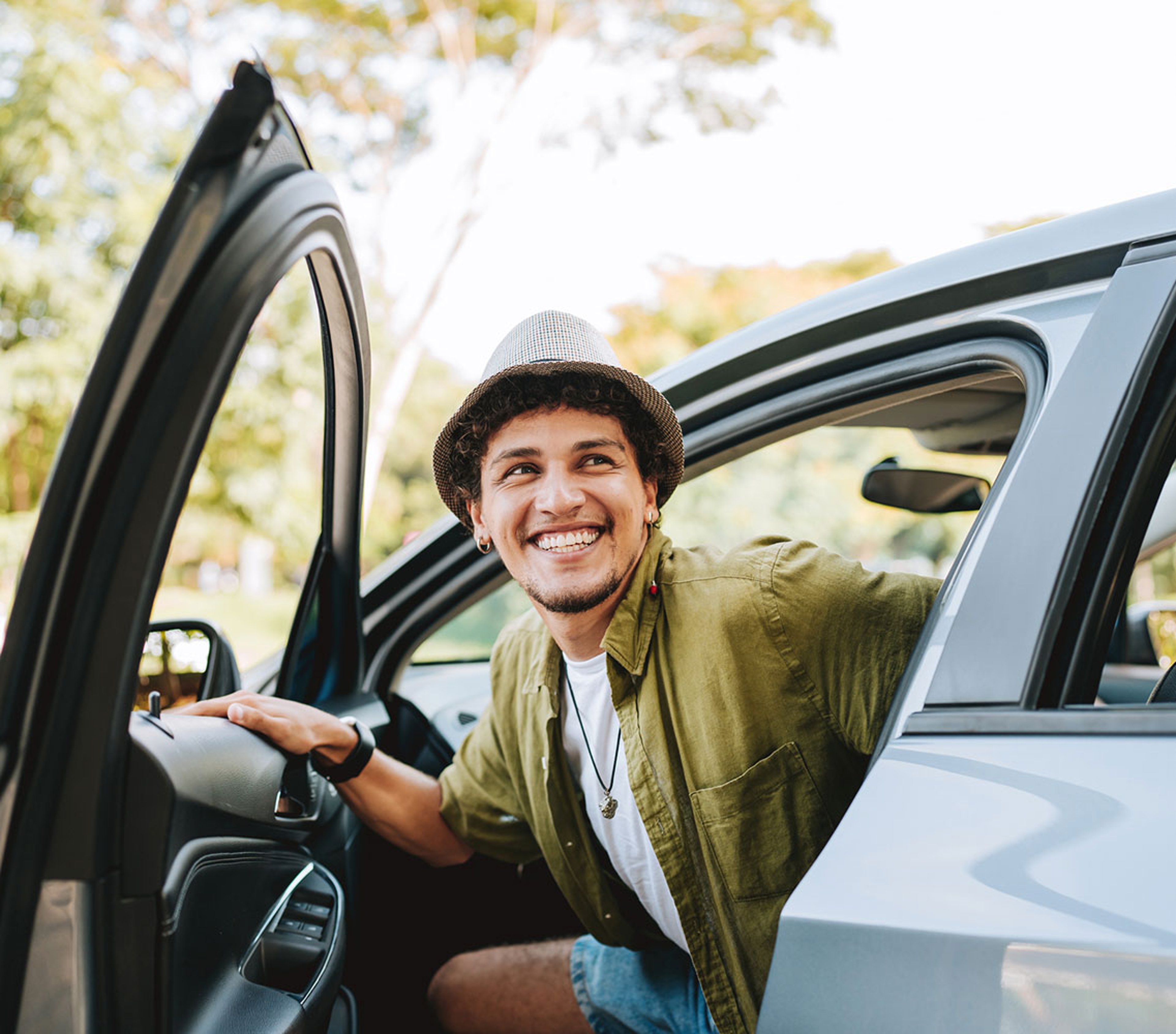 Young man traveling by car getting out of the car