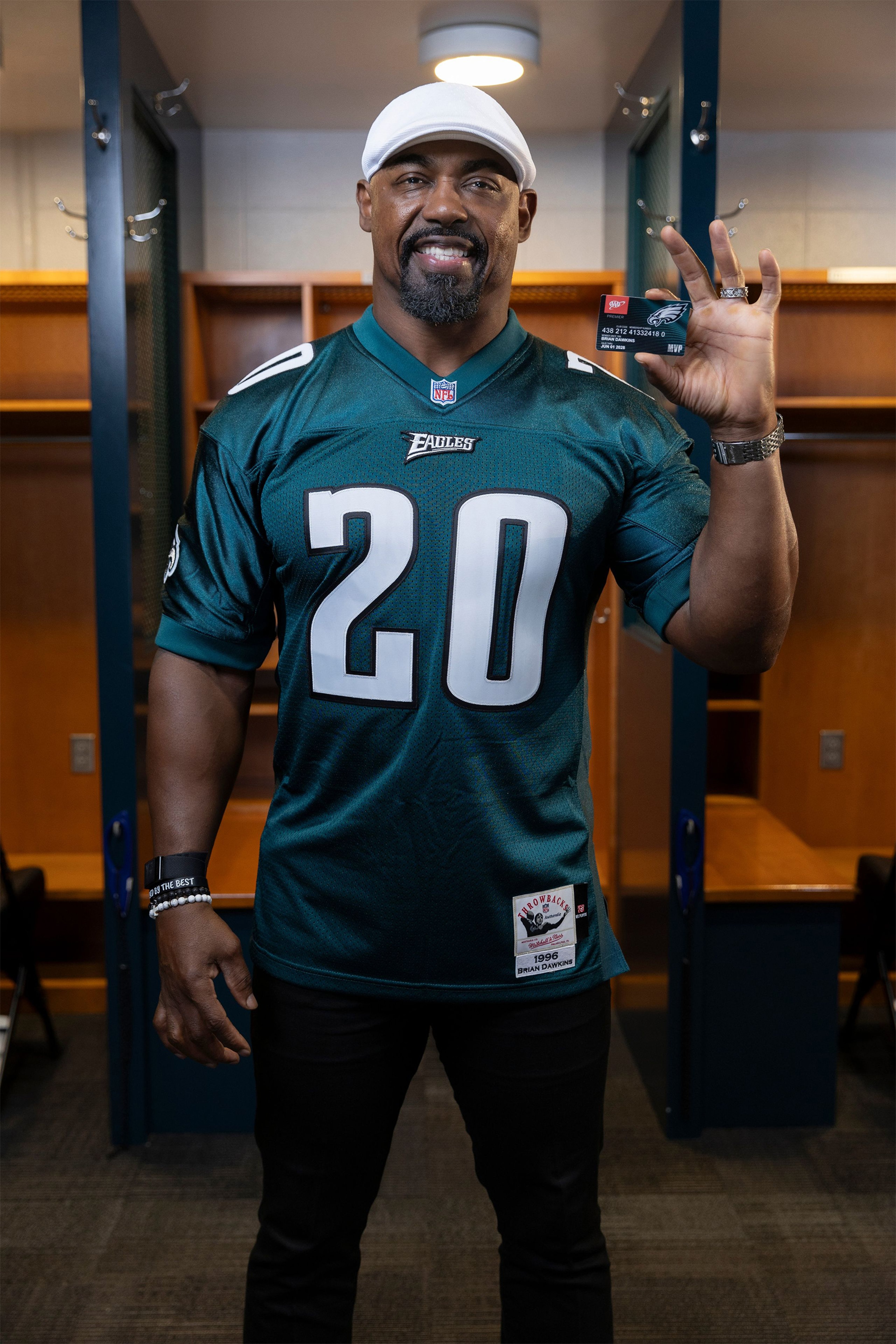 Philadelphia Eagles legend Brian Dawkins holding his AAA Eagles MVP card in the Eagles locker room