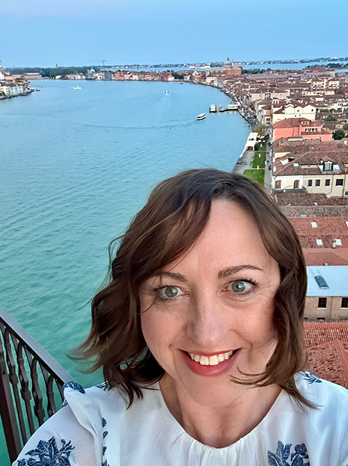 Martin Travel Advisor Kelley Beane standing on balcony overlooking Venetian bay