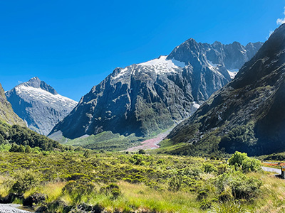 Mountains and grasslands under blue skies at Arthur's Pass National Park in New Zealand