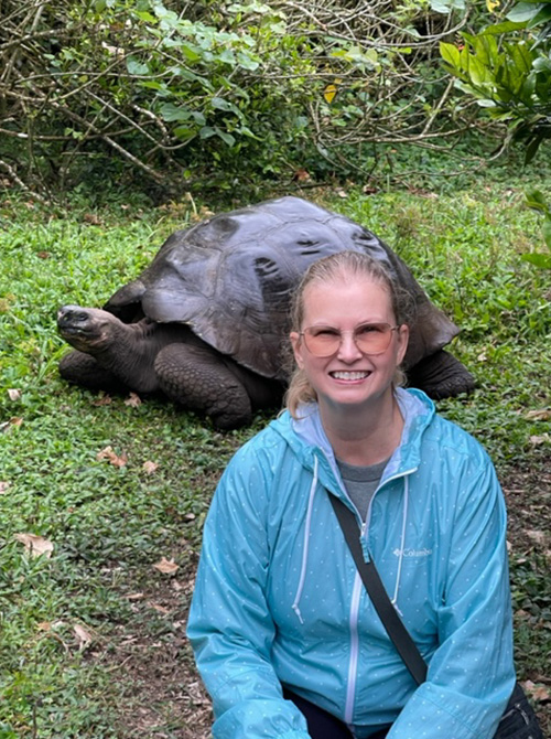 Travel Advisor Judy Miron, posing with Galapagos Giant Tortoise
