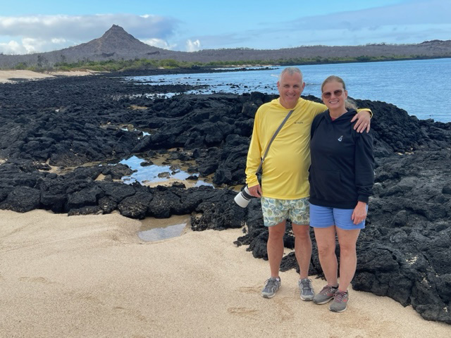 Tourists pose in front of volcanic mountains