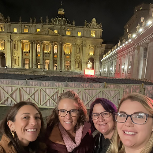 Group of smiling travelers at St. Peter's Basilica in Rome, Italy
