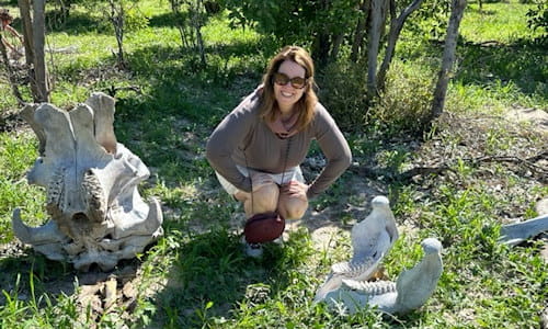 Tourist posing near skeletal remains in Africa