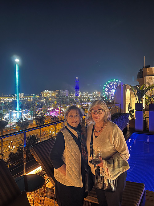 Provident travel advisors Ellen Wyler and Debra Clark at night on a rooftop