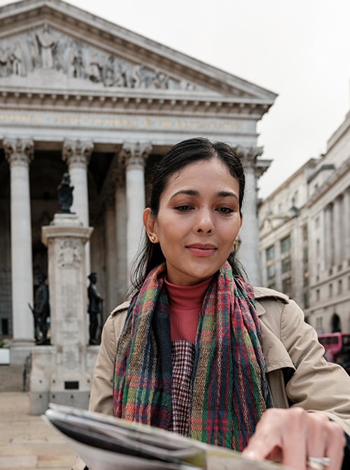 Traveler reviewing a map while exploring a historic city destination.