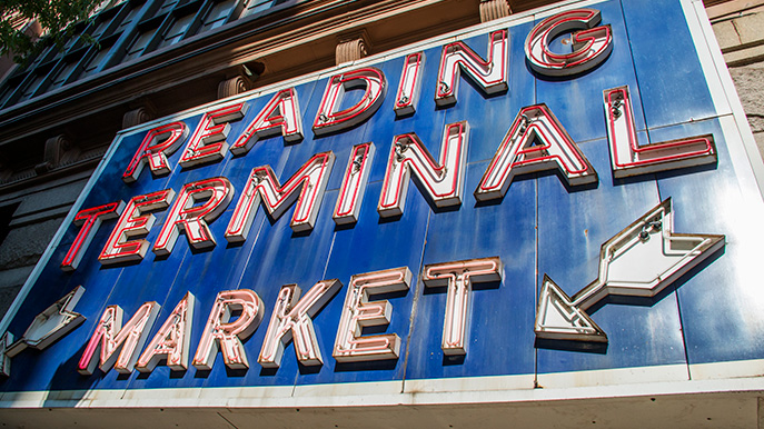 A large, vintage blue sign with red and white neon lights spelling out 