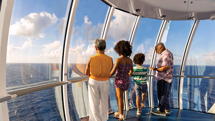 Family looks out from windowed observation deck on cruise ship