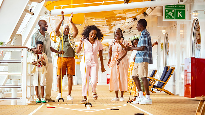 Multigenerational family enjoying a game of shuffleboard on a cruise ship