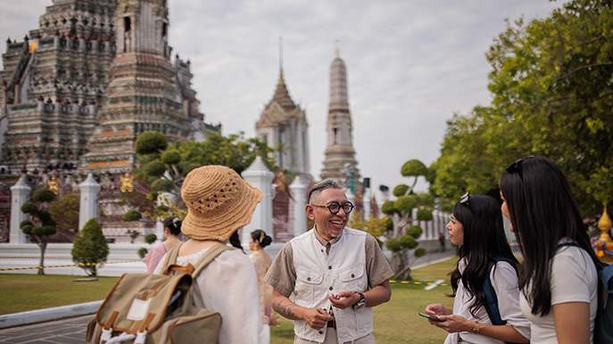 Women tourists with guide at temple in Bangkok, Thailand