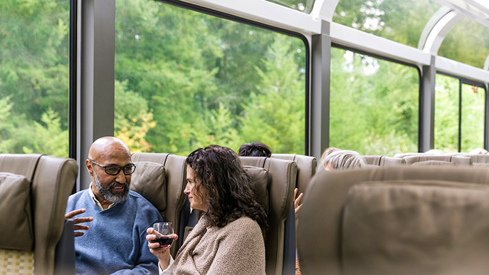 Couple toasting with wine traveling aboard luxury train in Europe