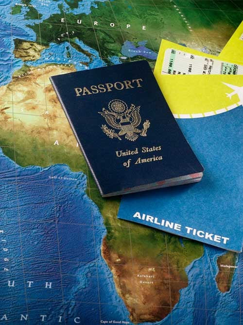 Blue passport on top of map and airline tickets