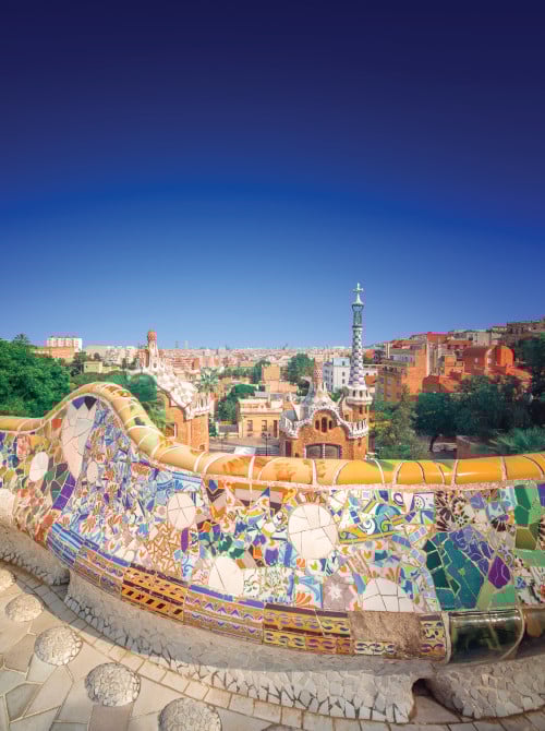 Colorful tiles on stone under blue skies at Park Güell in Barcelona, Spain