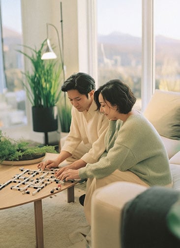 Asian couple playing game in their apartment