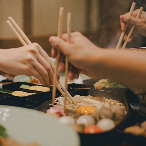 Several people sharing a hot pot meal