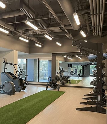 Apartment gym with turf strip, stair master, resistance sled and weights