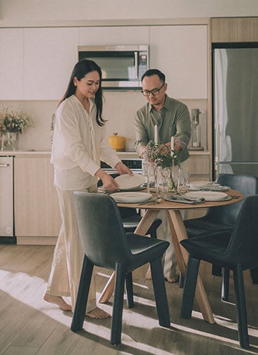 Man and woman setting the table in their apartment