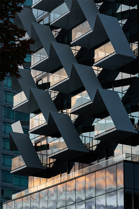 Closeup of Bosa Properties' Cardero building with a sunset reflecting off the building's windows