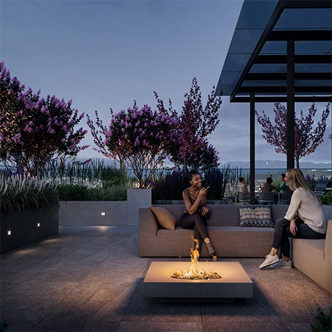 Women enjoying a rooftop lounge with a fire burning