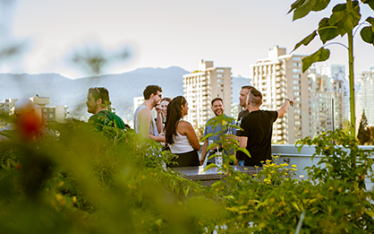 People chatting on a balcony with greenery around