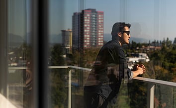 Man on a balcony overlooking greenery