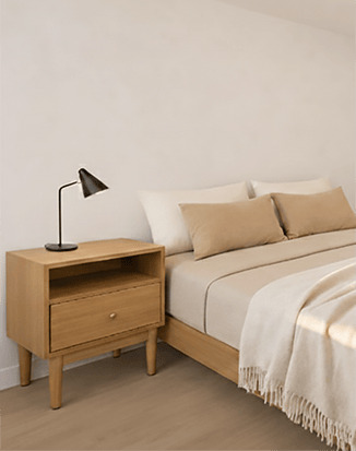 A bed with a wooden beside table