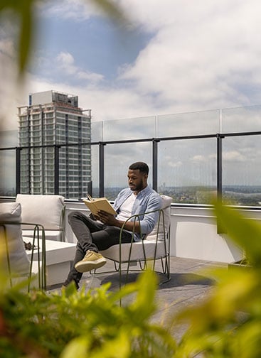 Man enjoying the sunny weather on a rooftop balcony
