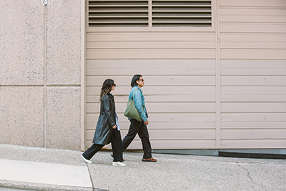 Two people walking down the street