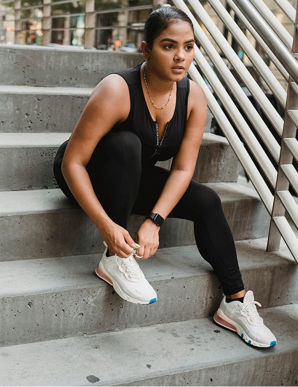 Girl tying her shoe on stairs