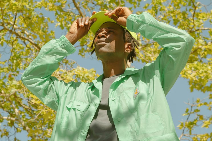 Guy holding his hat outdooors