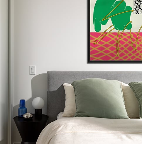 Bed with green pillow and artwork