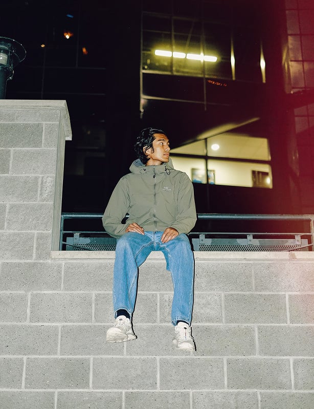 Man sitting on structure looking away