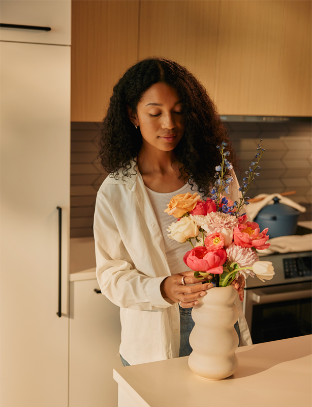 Woman arranging flowers on a kitchen island