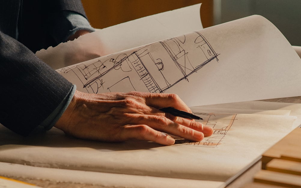 Hands working on architectural plans