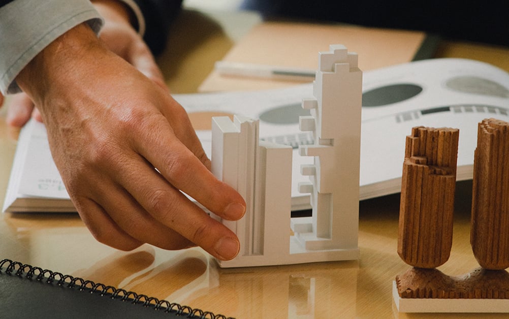 Hand moving building models across a desk