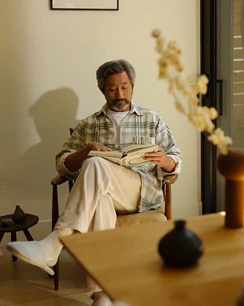 Man sitting in sunlight reading a book
