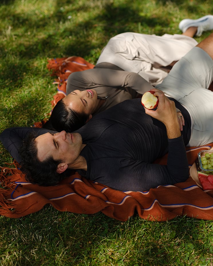 People lying on blanket in the grass